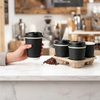Wholesale black and maroon double wall ripple paper coffee cups with lids on a white wooden background